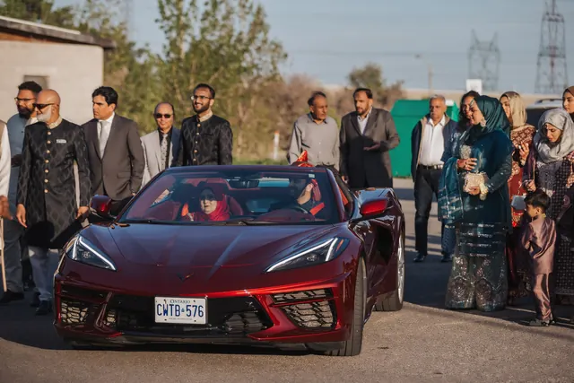 A red car and a crowd.