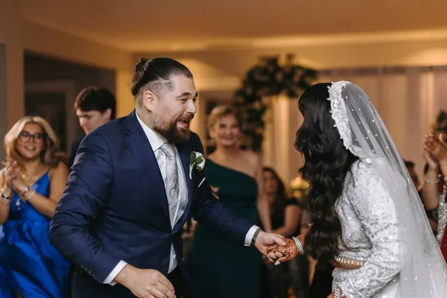 Hands joined, guests clapping.