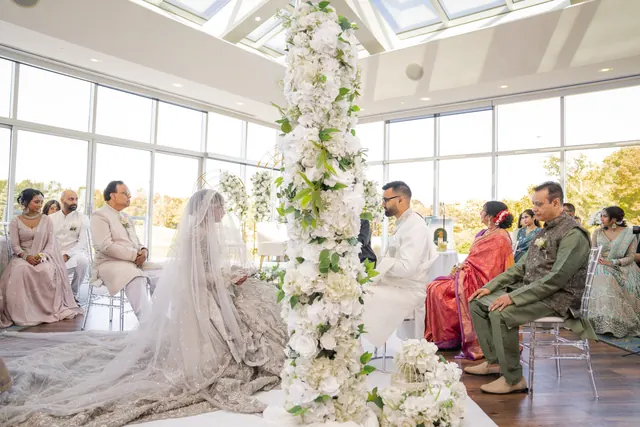 Seated by the flower pillar.